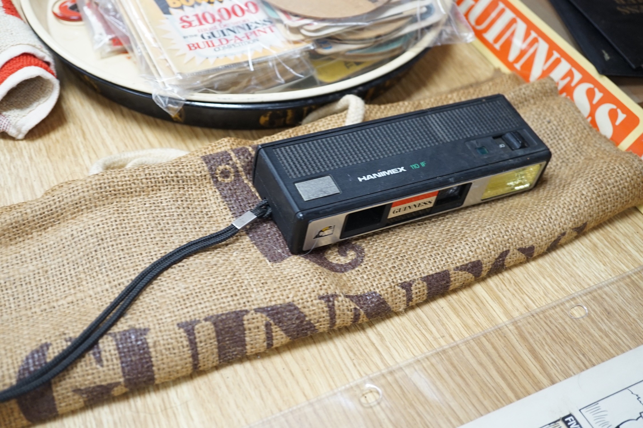 A large quantity Guinness advertising material, including a table lamp with Guinness shade, signage, bar mats, camera etc